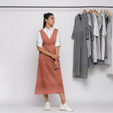 Front View of a Model wearing Rust 100% Linen V-Neck Midi Pinafore Dress