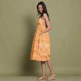 Left View of a Model wearing Rust Shibori Halter Neck Gathered Dress