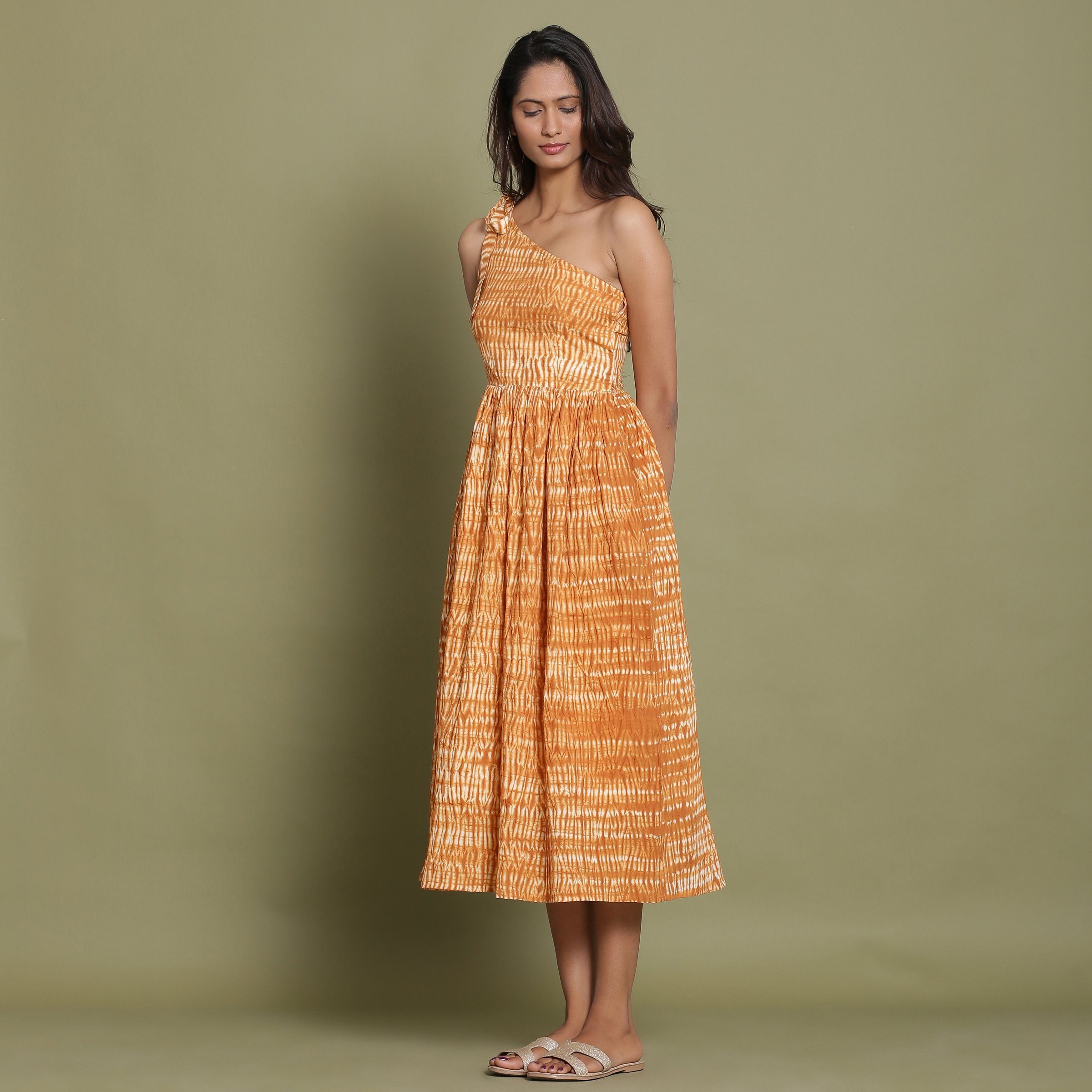 Left View of a Model wearing Rust Shibori One-Shoulder Midi Dress