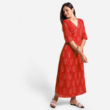 Left View of a Model wearing Sunset Orange Dabu Print 100% Cotton Wrap Dress