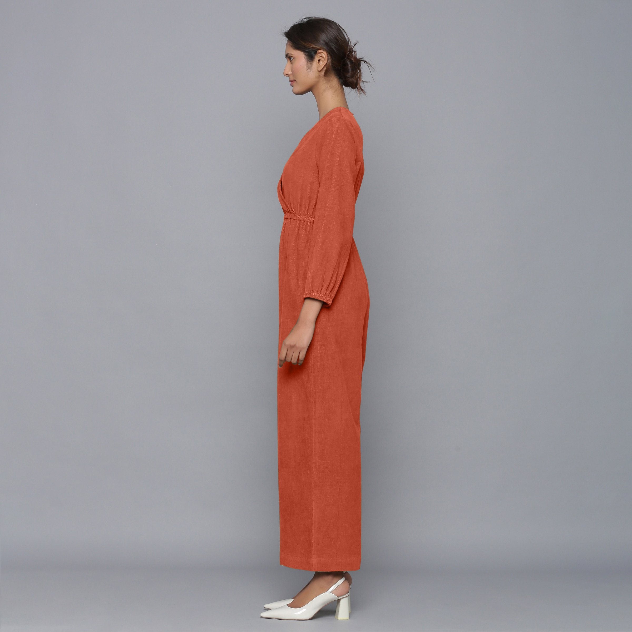 Left View of a Model wearing Sunset Rust Corduroy Comfy Jumpsuit