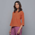 Left View of a Model wearing Sunset Rust Corduroy Drop Shoulder Top