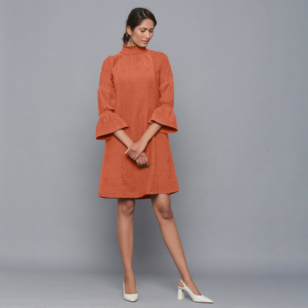 Front View of a Model wearing Sunset Rust Corduroy High Neck Dress