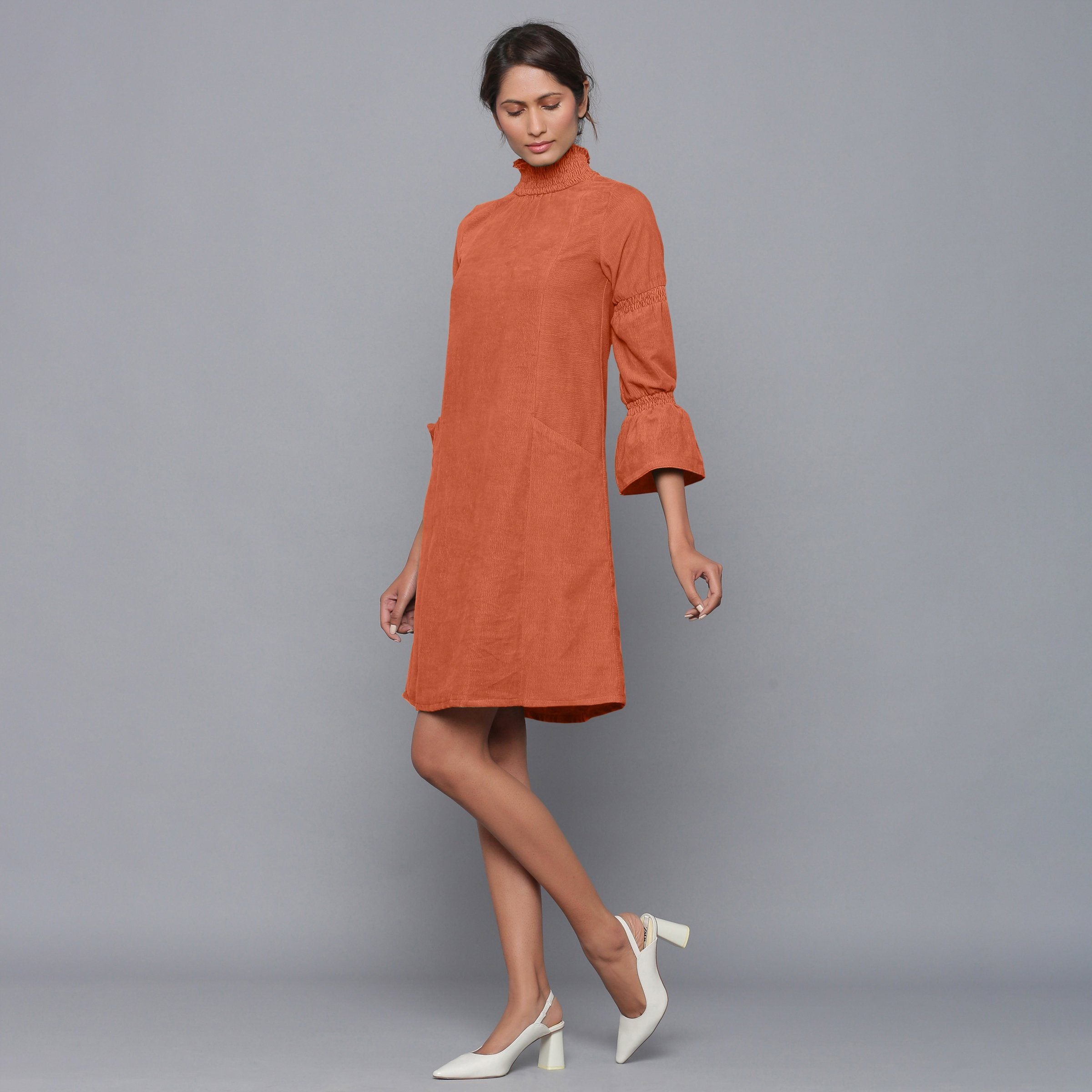 Left View of a Model wearing Sunset Rust Corduroy High Neck Dress