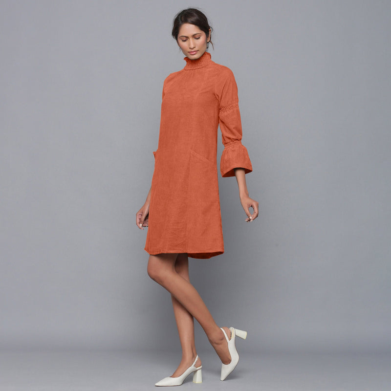 Left View of a Model wearing Sunset Rust Corduroy High Neck Dress