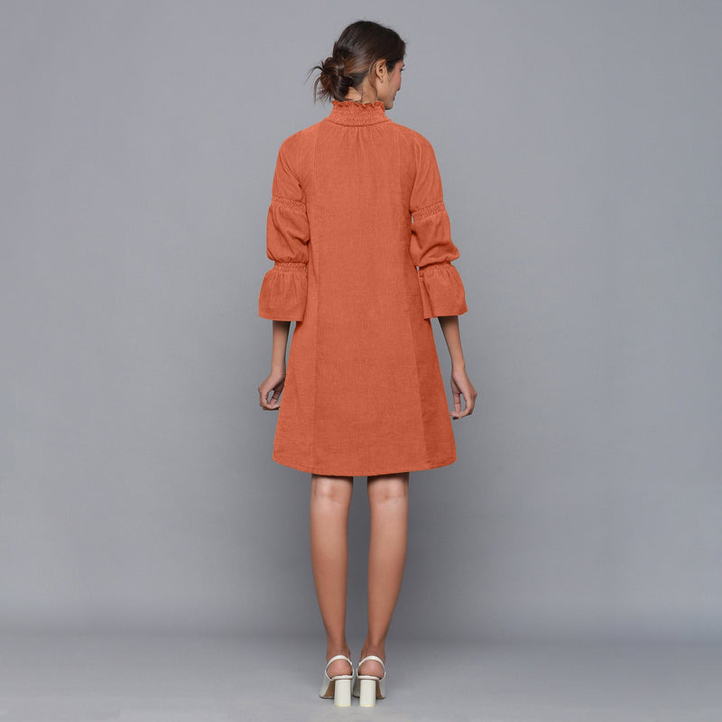Back View of a Model wearing Sunset Rust Corduroy High Neck Dress