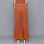 Back View of a Model wearing Sunset Rust Corduroy Striped Bootcut Pant