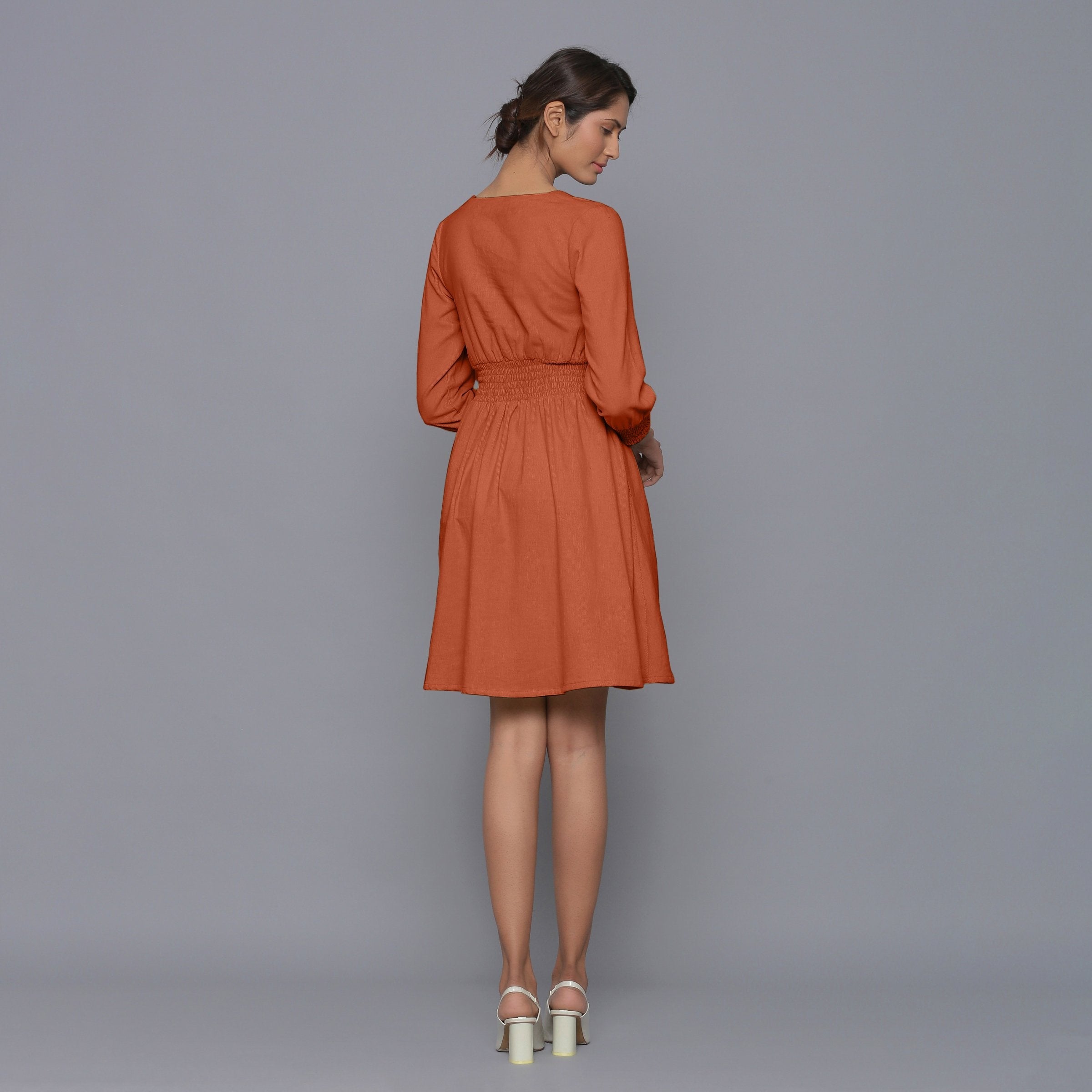 Back View of a Model wearing Sunset Rust V-Neck Corduroy Dress