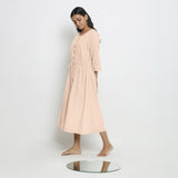 Left View of a Model wearing Vegetable-Dyed Light Pink 100% Cotton Button-Down Dress