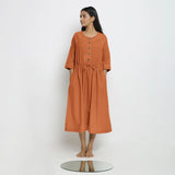 Front View of a Model wearing Vegetable-Dyed Orange 100% Cotton Button-Down Dress