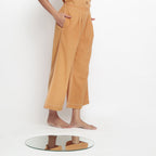 Right View of a Model wearing Rust Vegetable Dyed Cotton Elasticated Wide Legged Pant