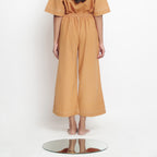 Back View of a Model wearing Rust Vegetable Dyed Cotton Elasticated Wide Legged Pant