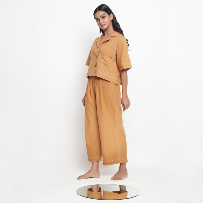 Left View of a Model wearing Rust Vegetable Dyed Cotton Elasticated Wide Legged Pant