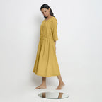 Left View of a Model wearing Vegetable-Dyed Yellow 100% Cotton Button-Down Dress