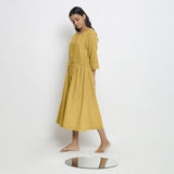 Left View of a Model wearing Vegetable-Dyed Yellow 100% Cotton Button-Down Dress