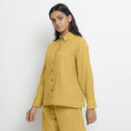 Left View of a Model wearing Vegetable Dyed Yellow Button-Down Cotton Top