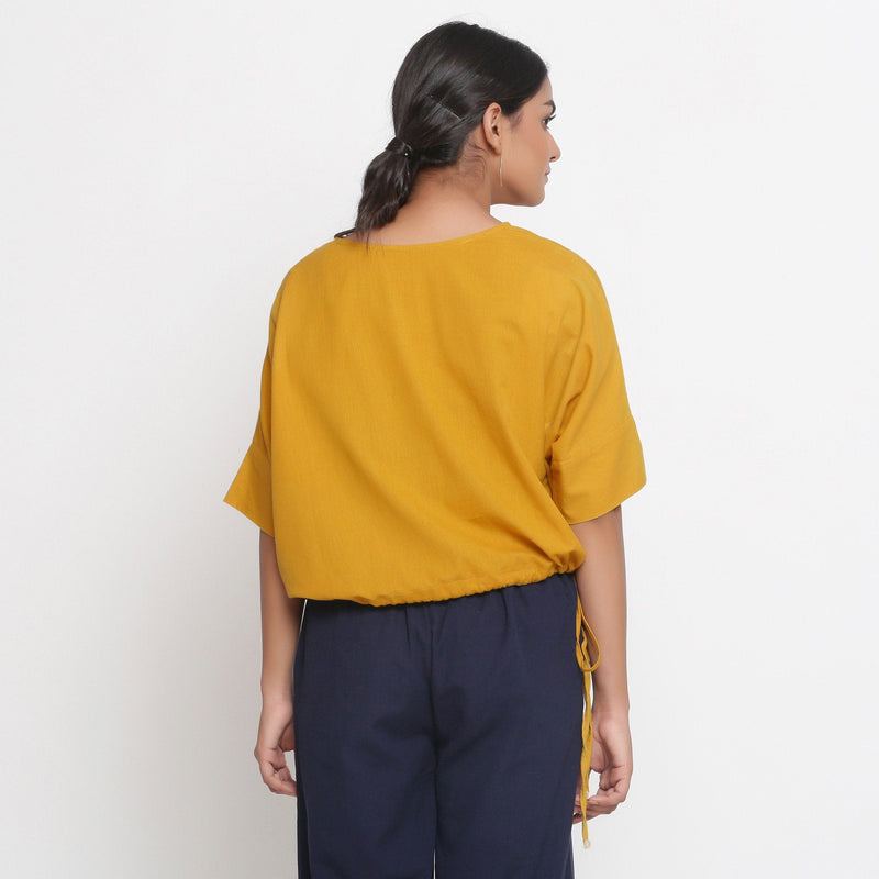 Back View of a Model wearing Solid Yellow Cotton Flax Blouson Top