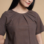 Front Detail of a Model wearing Brown Pleated Neck A-Line Top