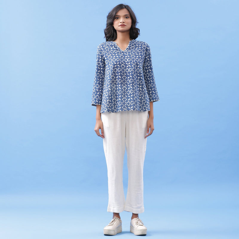 Front View of a Model wearing Indigo Flared Top and Off-White Tapered Pant Set