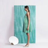 Left View of a Model wearing Ocean Green Handspun 100% Cotton A-Line Dress