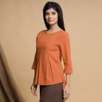 Left View of a Model wearing Orange Box-Pleated High Low Top