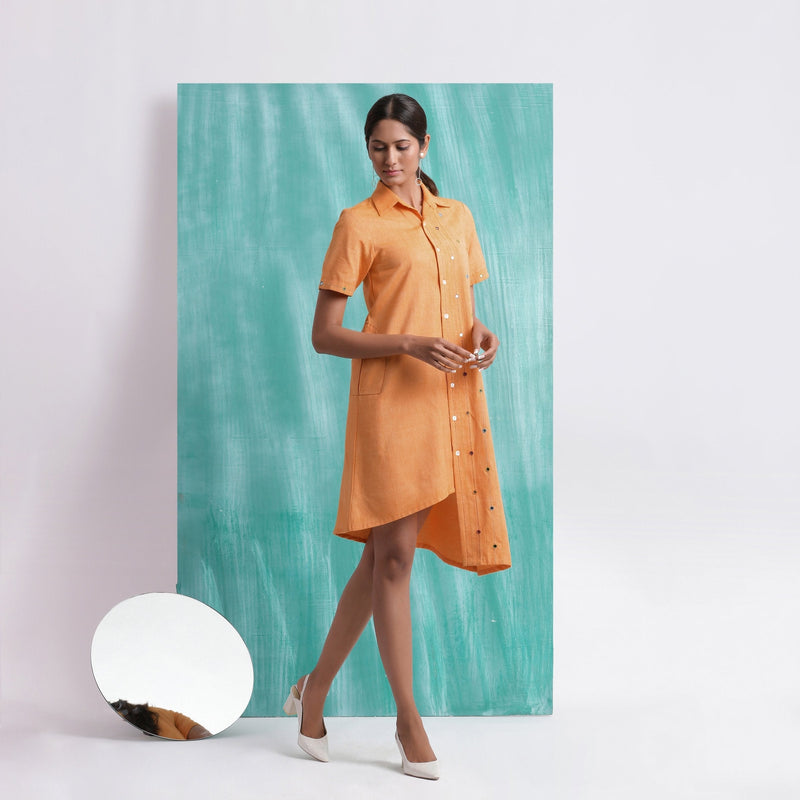 Right View of a Model wearing Orange Mirrored Asymmetrical Shirt Dress