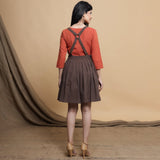 Back View of a Model wearing Orange Pleated Top and Brown Dress Set