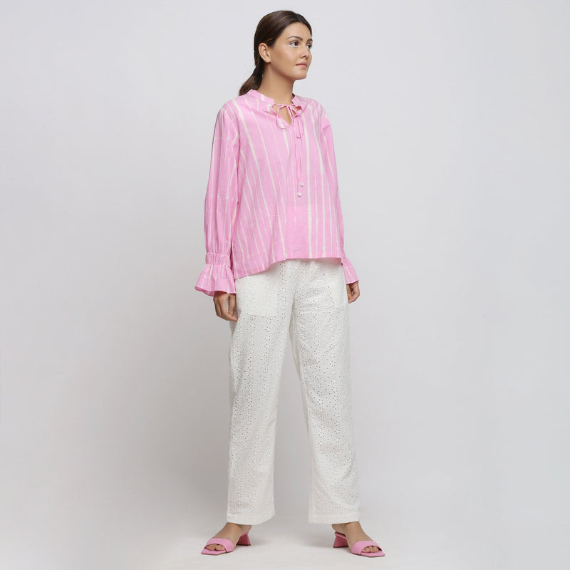 Right View of a Model wearing Pink Blouson Top and White Straight Pant Set