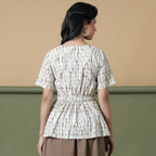 Back View of a Model wearing Shibori Button-Down Peplum Top